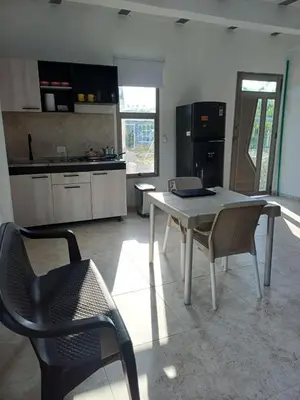 a kitchen with a white table and chairs in a room at Apartaestudio en Tierra Bomba in Isla de Tierra Bomba