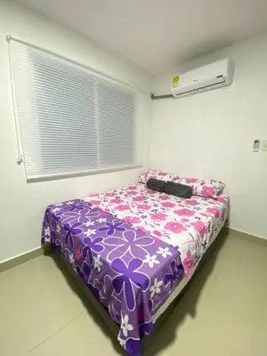 a bedroom with a bed with a purple comforter at Apartamento BBB para 4 pax en La Boquilla in Cartagena de Indias