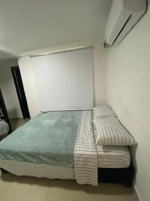 a bed in a room with a white wall at Cómodo & Económico Apartamento en La boquilla BBB 4 pax in Cartagena de Indias