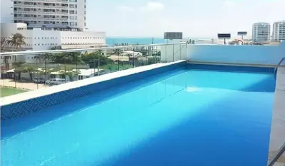 a large blue swimming pool on top of a building at Apartamento en Cartagena Marbella in Cartagena de Indias