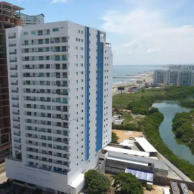 a tall white building next to the ocean at Apartamento en Cartagena Marbella in Cartagena de Indias