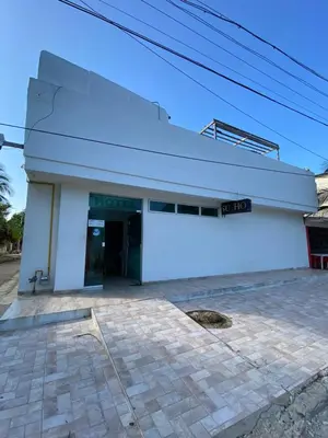 a white building with a door on it at Hotel Nellamar in Puerto Colombia