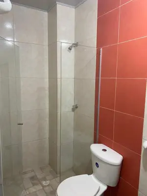 a bathroom with a toilet and a glass shower at Hotel Nellamar in Puerto Colombia
