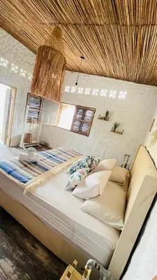 a large bed in a bedroom with a ceiling at Puerto idilio beach resort in Isla Grande