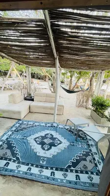 a living room with a blue and white rug at Puerto idilio beach resort in Isla Grande