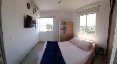 a small bedroom with a bed and two windows at 406 Sea Breeze and Luxury in Cartagena in Cartagena de Indias