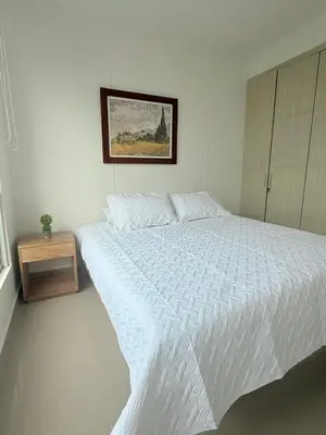 a white bedroom with a white bed and a table at Hermoso Apartamento Frente al Mar 3 Habitaciones AR54 in Coveñas