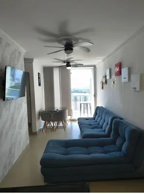 a living room with a blue couch and a table at Piso 2206 Mirador de Cartagena in Cartagena de Indias