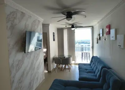 a living room with a blue couch and a television on a wall at Piso 2206 Mirador de Cartagena in Cartagena de Indias