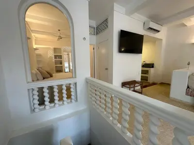 a room with a staircase with a mirror and a television at Casa Miramar by Soho in Cartagena de Indias