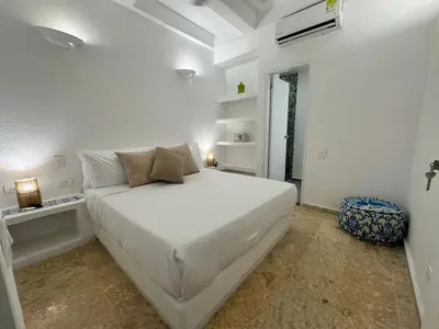 a white bedroom with a large white bed in it at Casa Miramar by Soho in Cartagena de Indias