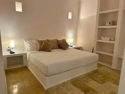 a bedroom with a white bed with two shelves at Casa Miramar by Soho in Cartagena de Indias