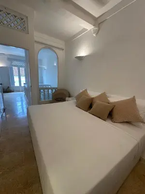 a bedroom with a white bed with pillows on it at Casa Miramar by Soho in Cartagena de Indias