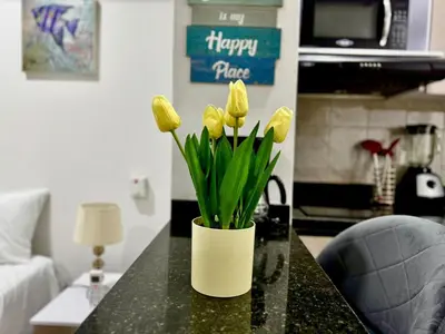 a vase filled with yellow tulips on a table at CARTAGENA BEACHT - APARTAESTUDIO A 100 mt del mar - Piscina, Jacuzzi in Cartagena de Indias