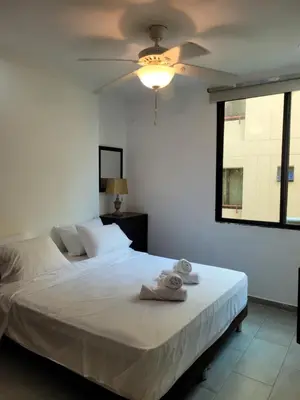 a bedroom with a white bed with a ceiling fan at Apto en EL Cabrero, Edificio Manzanillo del Mar in Cartagena de Indias