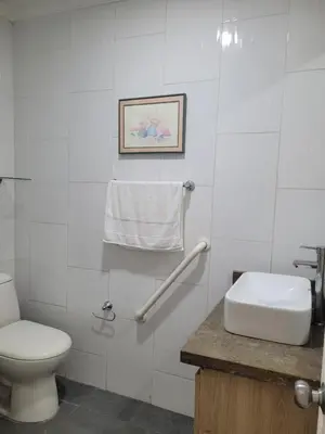 a white bathroom with a toilet and a sink at Apto en EL Cabrero, Edificio Manzanillo del Mar in Cartagena de Indias