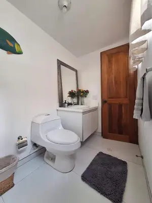 a white bathroom with a toilet and a mirror at Great Apartment With Private Pool in Cartagena de Indias