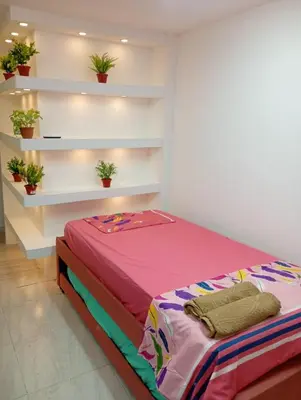 a bed in a room with plants on shelves at La Escalera de Getsemani in Cartagena de Indias