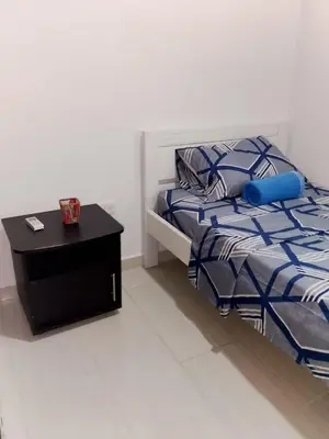 a bedroom with a bed and a table with a blue pillow at Apartamento de 3 habitaciones, al norte de Barranquilla, via a Cartagena, aire acondicionado en sala y todas las habitaciones, excelenten para trabajo o descanso in Barranquilla