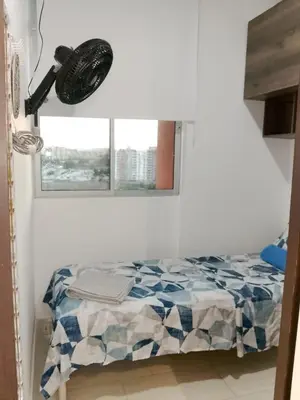 a bedroom with a bed with a lamp and a window at Apartamento de 3 habitaciones, al norte de Barranquilla, via a Cartagena, aire acondicionado en sala y todas las habitaciones, excelenten para trabajo o descanso in Barranquilla