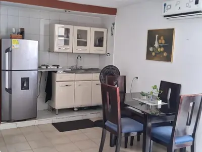 a kitchen with a table and a refrigerator at La perla in Cartagena de Indias