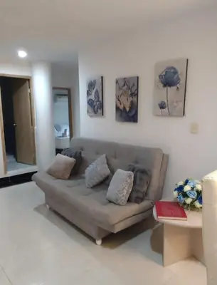 a living room with a couch and paintings on the wall at Apartamento en Cielo Mar in Cartagena de Indias