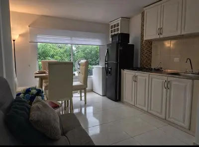 a kitchen with a couch and a table and a refrigerator at Apartamento en Cielo Mar in Cartagena de Indias