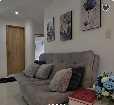a living room with a couch and some pictures on the wall at Apartamento en Cielo Mar in Cartagena de Indias
