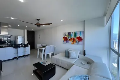 a living room with a white couch and a kitchen at Exclusivo apartamento vista al mar in Santa Marta