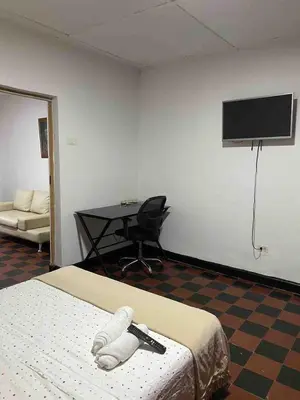 a room with a bed and a desk and a television at Entire apartment bathroom AC Smart tv wifi kitchen in Barranquilla