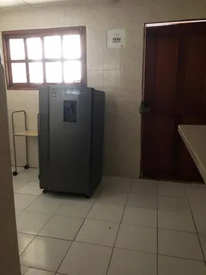 a black refrigerator in a room with a window at Entire apartment bathroom AC Smart tv wifi kitchen in Barranquilla