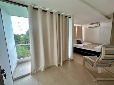a bedroom with a bed and a window and a chair at Apto Familiar Moderno Cerca de Todo en Coveñas in Coveñas