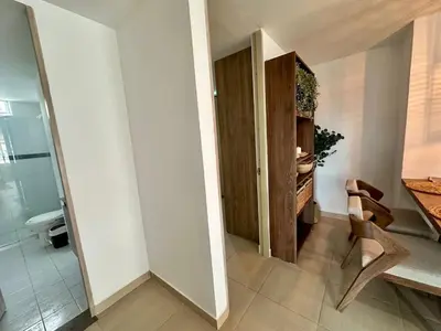 a hallway with a table and a chair and a bathroom at Apto Familiar Moderno Cerca de Todo en Coveñas in Coveñas