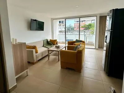 a living room with a couch and chairs and a tv at Apto Familiar Moderno Cerca de Todo en Coveñas in Coveñas
