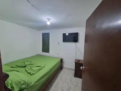 a bedroom with a green bed and a flat screen tv at Julius cartagena in Cartagena de Indias