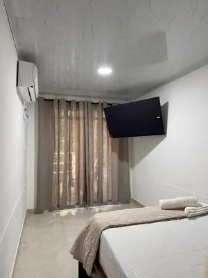 a room with a bed and a tv on the wall at Orilla beach house in Playa Punta Arena
