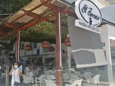a woman taking a picture of a sign in front of a restaurant at 1401 Apartamento con AC, Piscina y Cerca Playa in Cartagena de Indias