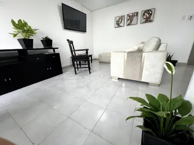 a living room with a couch and a chair at 1401 Apartamento con AC, Piscina y Cerca Playa in Cartagena de Indias