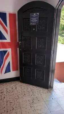 a black door with a british flag behind it at Central Point Air BAQ in Barranquilla