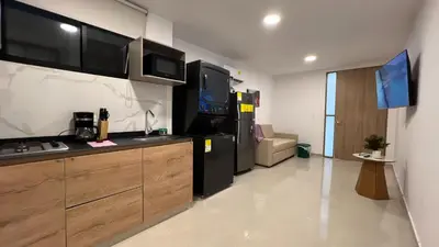 a kitchen with a refrigerator and a tv in a room at Sofia del Mar in Puerto Colombia