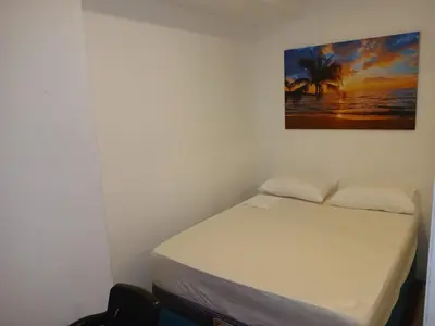 a bed in a room with a picture on the wall at Apartasuite Marbella in Cartagena de Indias