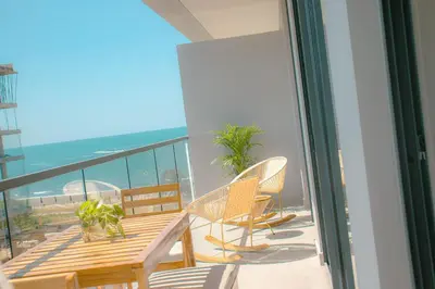 a balcony with chairs and a table and a view of the ocean at Morros Serena del Mar in Cartagena de Indias