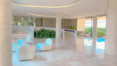 a lobby with blue chairs and a swimming pool at Morros Serena del Mar in Cartagena de Indias