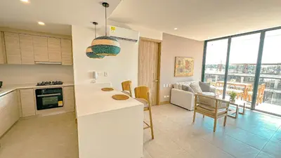 a kitchen with a counter top and a living room at Morros Serena del Mar in Cartagena de Indias