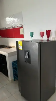 two wine glasses on top of a refrigerator in a kitchen at Apartamento Yulenis Coveñas in Guayabal