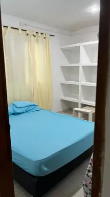 a blue bed in a room with shelves at Apartamento Yulenis Coveñas in Guayabal