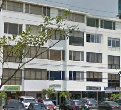a large white building with cars parked in front of it at Apartaestudio Económico en Cartagena, al lado de la Playa in Cartagena de Indias