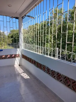 a balcony with a view of trees through the windows at Mararena in Coveñas