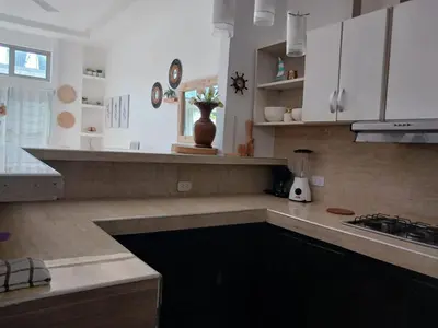 a kitchen with white cabinets and a counter top at Mararena in Coveñas