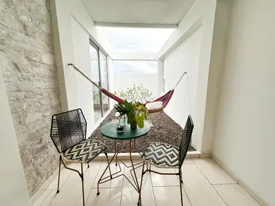 a room with a table and chairs and a hammock at Villa in Sabanilla near the Sea in Maizal